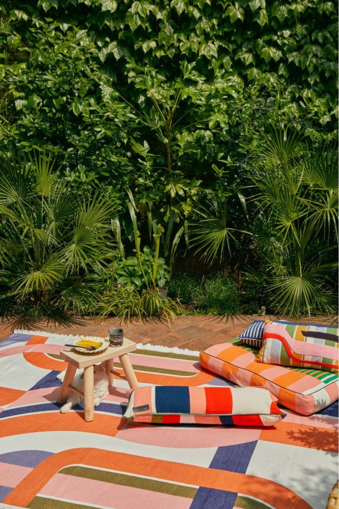 alt =  aménagement décoration espace extérieur terrasse tapis extérieur et coussins colorés